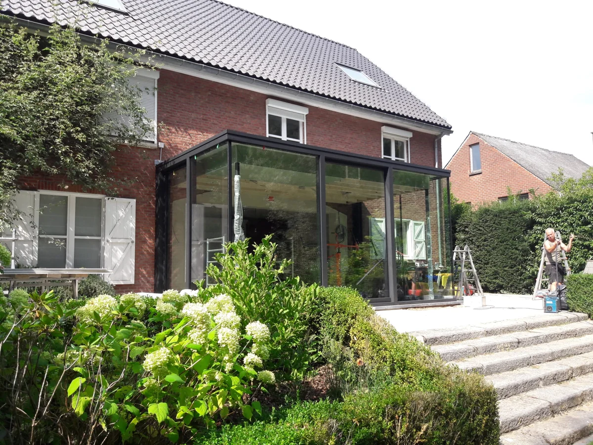 Moderne glazen aanbouw met donkere aluminium profielen