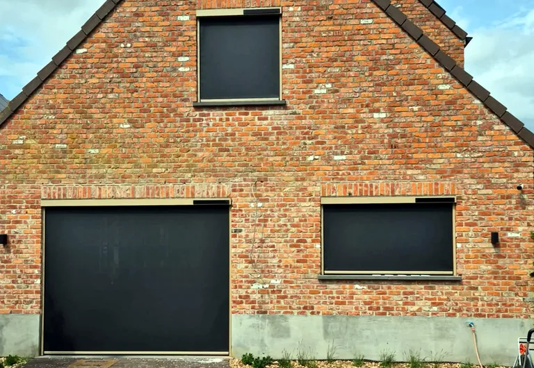 Donkere zonwerende screens op een bakstenen woning