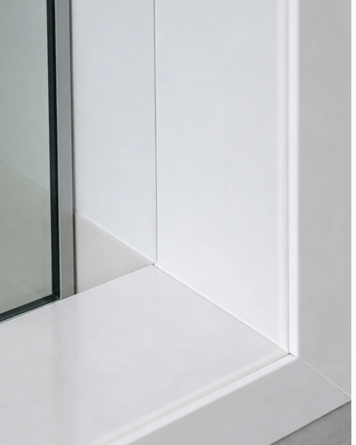 Detail van glad PVC paneel, afwerkprofiel en afgekitte aansluiting